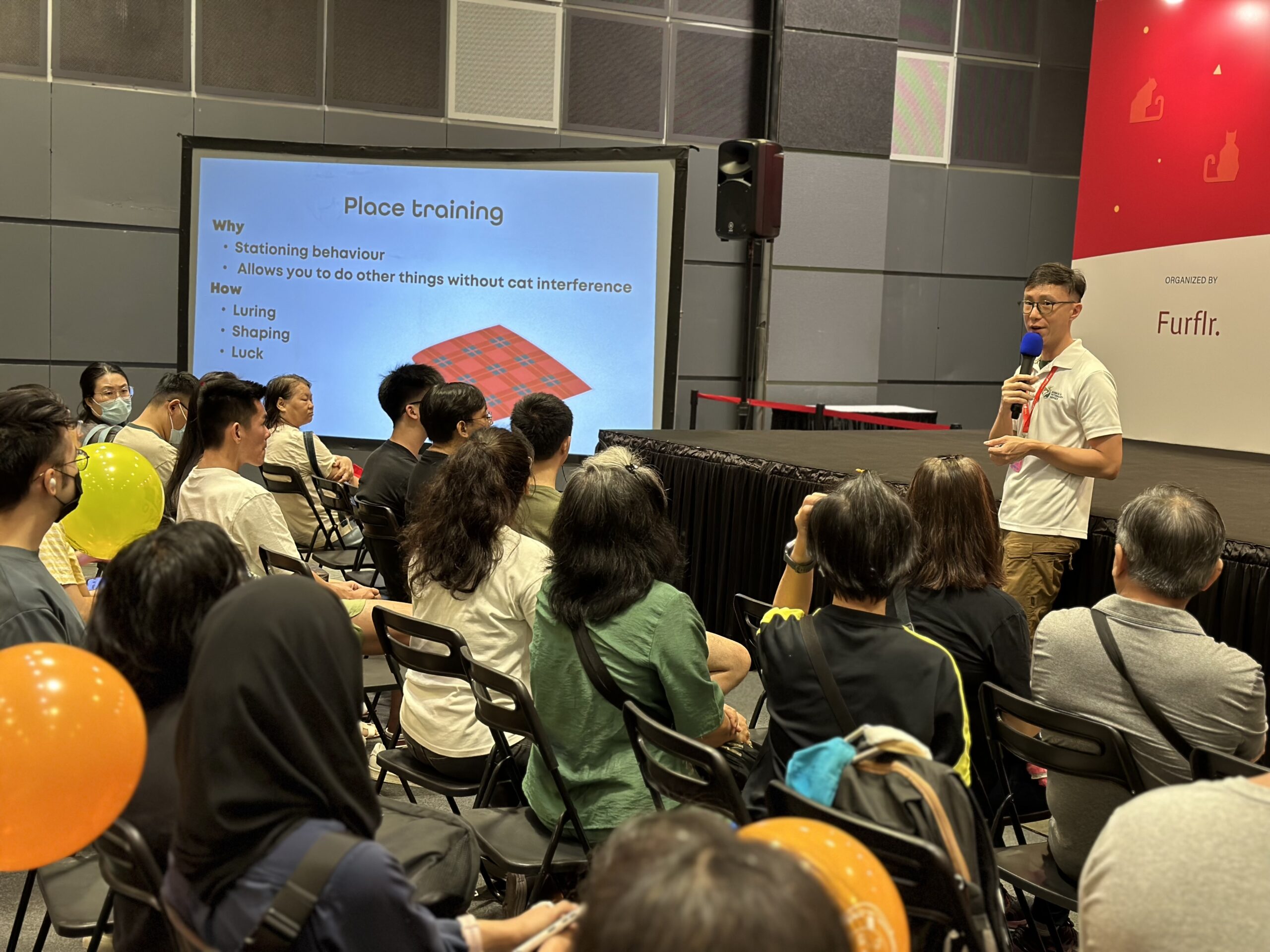 Head Coach Webster giving a talk on positive pet training to a large attentive audience at Asia Cat Expo.