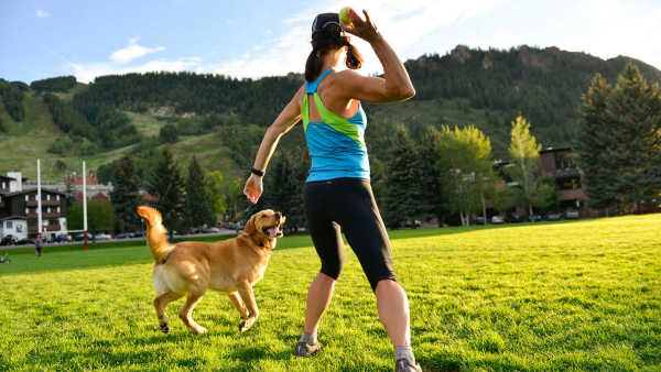 Image showing a lady and her furry canine companion enjoying a stimulating play, reaping the benefits of canine fitness and conditioning.